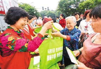 6月4日，江西省新余市渝水区城北街道办的志愿者在恭惠农贸市场门口向群众免费发放环保袋。周 亮摄（人民视觉）